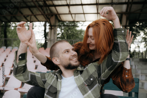 lovers fool around sitting on the stand of the stadium