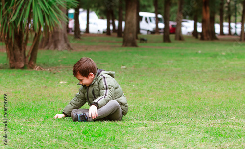 Hispanic boy sitting on the grass in the park