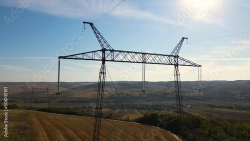 Steel pillar with high voltage electric power lines delivering electrical energy through cable wires on long distance photo