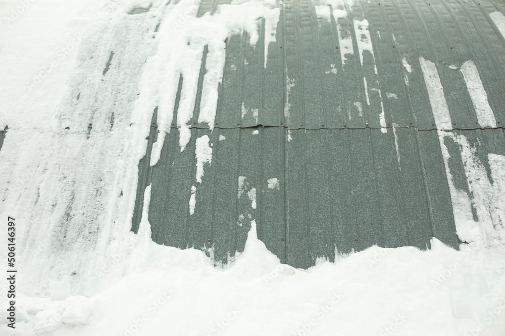 Steel structure in snow. Wall of warehouse after snowstorm. Hedged hangar.