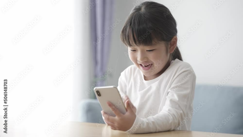 リビングでスマートフォンを使う女の子 リビングでスマートフォンを使う女の子