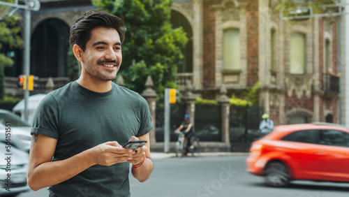 Handsome mexican man smiling with email in his hands sending text messages.
