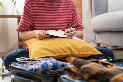 people check clothes into luggage in suitcase checklist before holidays trip