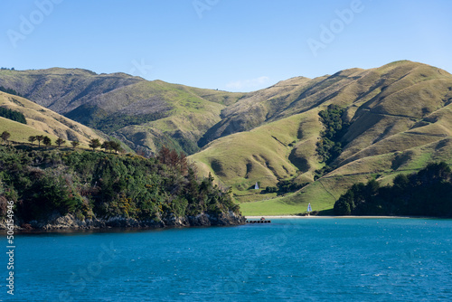 Small bay and rolling hill farmland in Marlborough Sounds viewed from sea. © Brian Scantlebury