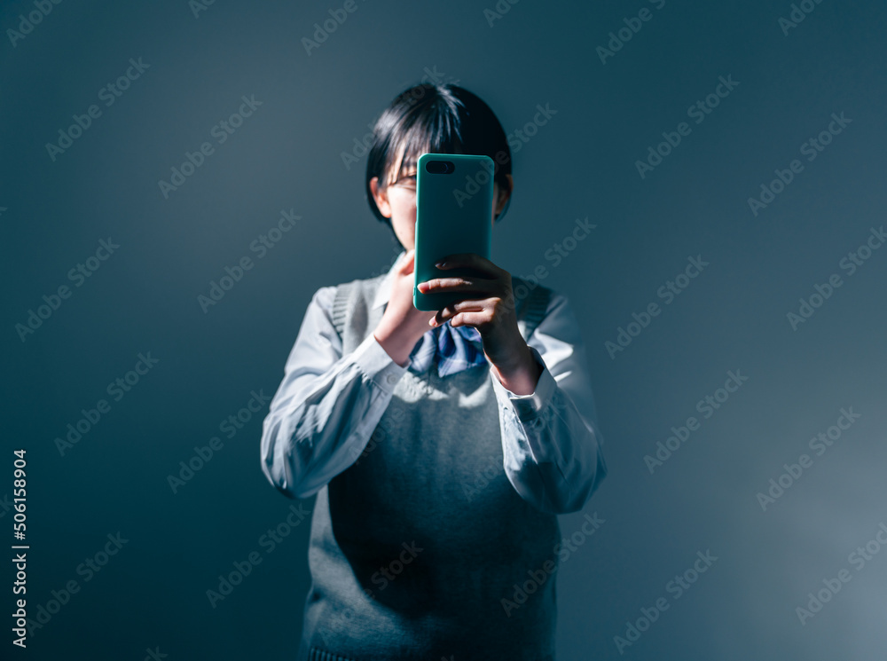 スマートフォンを見て不安になる女子高校生 スマートフォンを見て不安になる女子高校生