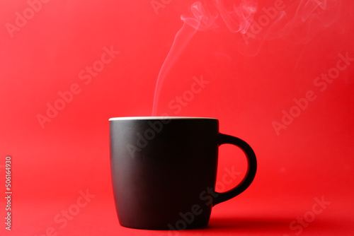 Ceramic cup with hot drink on color background