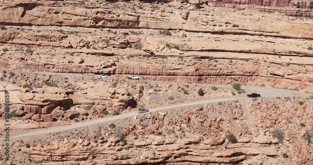 Moki Dugway vehicle traffic on steep road southern Utah. Roadway carved from a mountain cliff. Scenic Backway and very narrow. Near the Valley of the Gods and Monument Valley. Trail of the Ancients. Moki Dugway vehicle traffic on steep road southern Utah. Roadway carved from a mountain cliff. Scenic Backway and very narrow. Near the Valley of the Gods and Monument Valley. Trail of the Ancients.