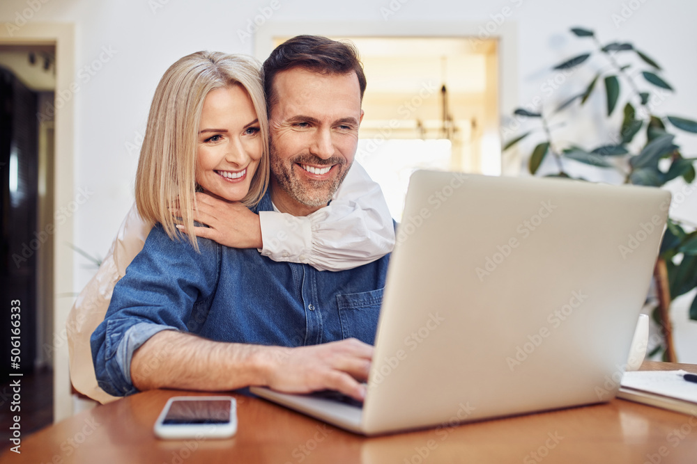 Happy middle aged couple doing online shopping on laptop Happy middle aged couple doing online shopping on laptop