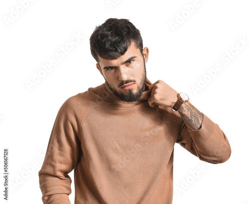 Bearded man adjusting collar on white background