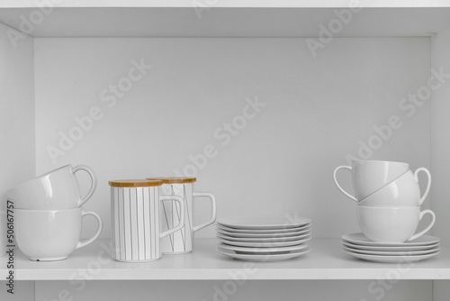 Shelf with beautiful dinnerware in kitchen