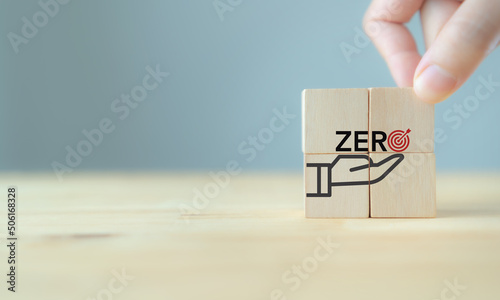 Zero target concept. Zero of accident, carbon emissions, waste, net zero. Business goal and target achievement. Placed wooden cube with zero target, achievement icon on smart background.