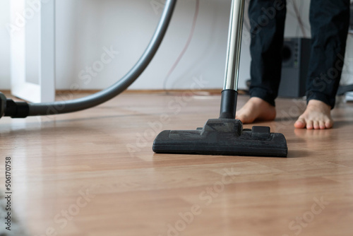 doing clean up at home, using vacuum cleaner to wash the floor