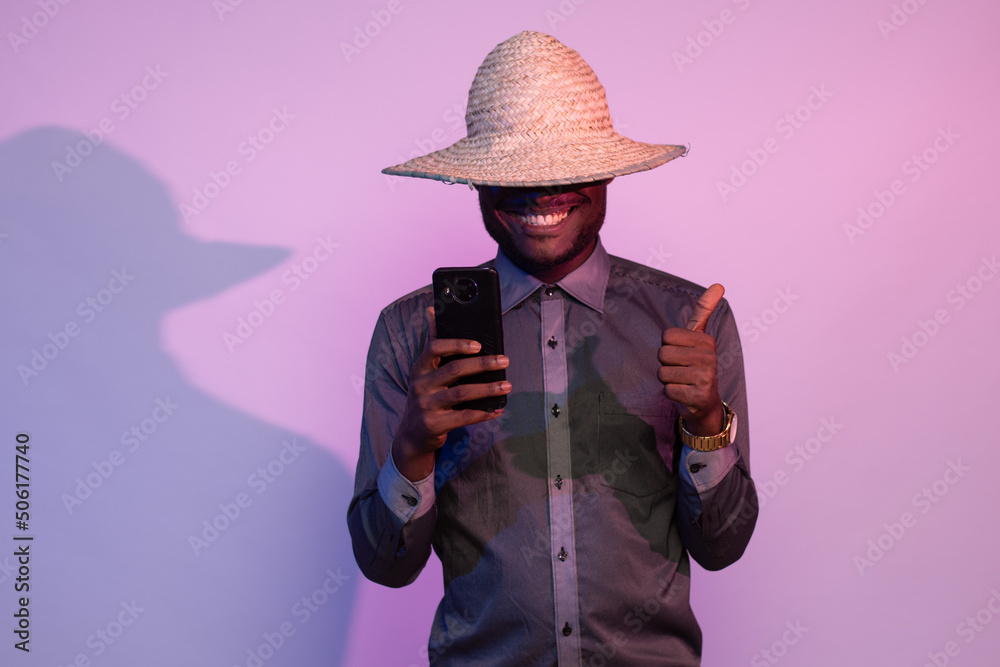 african man holding his phone, does thumbs up gesture african man holding his phone, does thumbs up gesture
