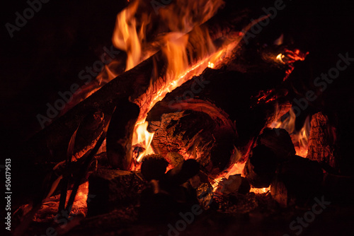 bright burning coals of a firewood fire in the dark