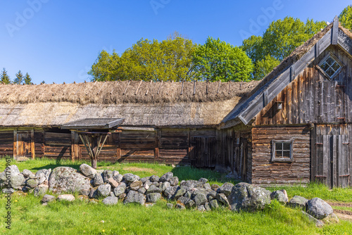 Rural timbered barn with thatched roof in the summer