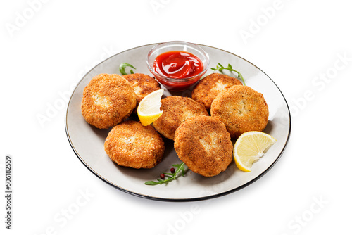 Chicken patties or fish cakes fried in breadcrumbs with ketchup and lemon slices. isolated on white background	