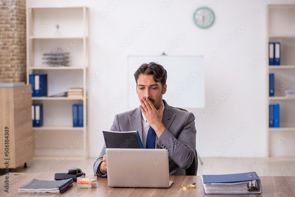 Young male employee sitting in the office Young male employee sitting in the office