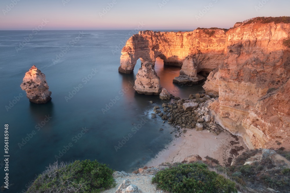 Natural arch above ocean. Natural caves at Marinha beach,  Algarve, Lagoa portugal. Stone arch at beach.
Summer season.