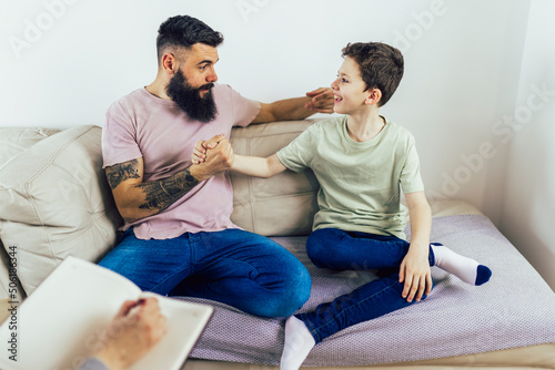 Internet addicted boy visiting therapist with his father