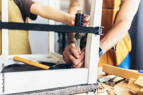 Close up photo of young male carpenter and his son working in workshop