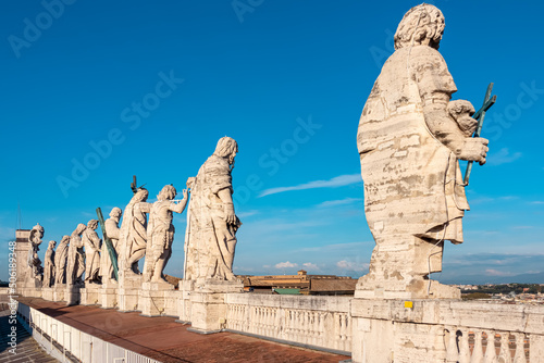 Rear close up view of statues on top of St Peter Basilica in Vatican City, Rome, Lazio, Europe, EU. Colonnade of 13 colossal statues near Michelangelos Dome. Landmark seen from the back