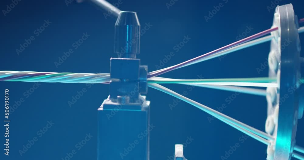 Twisting thin colored wires into one large one using a special mechanism in the workshop for the production of electrical wires for the defense industry. Twisting thin colored wires into one large one using a special mechanism in the workshop for the production of electrical wires for the defense industry.