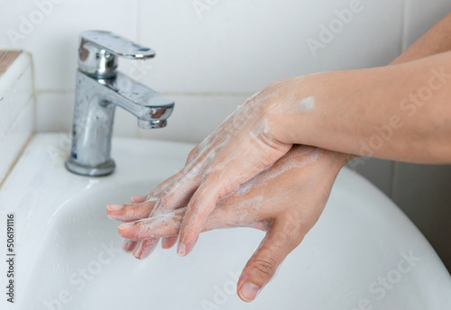 adults wash their hands with hand soap to prevent infection and viruses