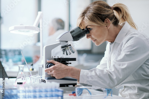 Professional scientist using a microscope photo