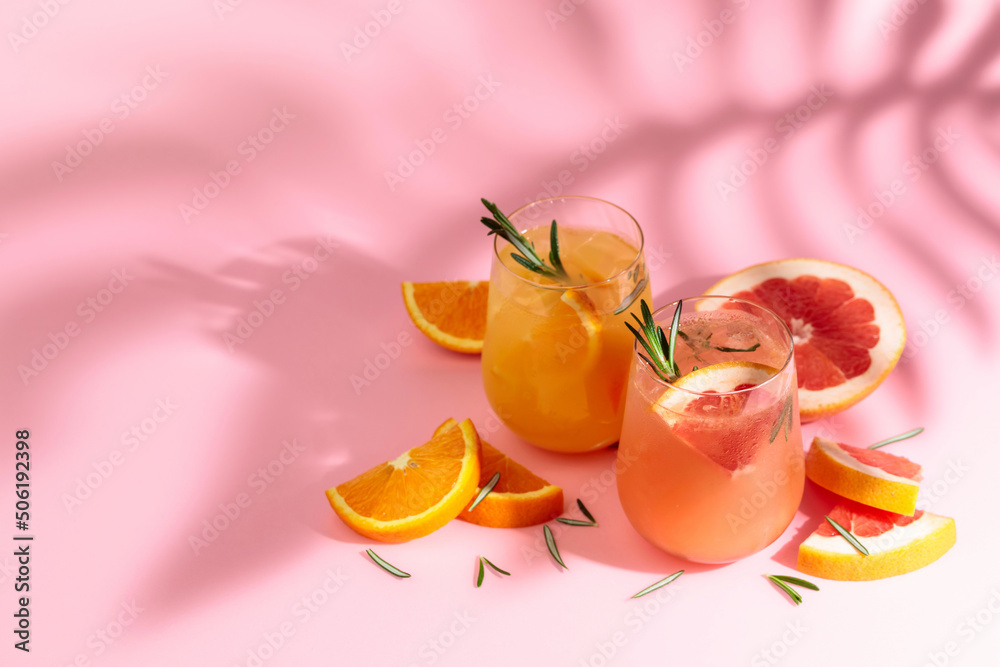 Summer cocktails with grapefruit, orange, rosemary, and ice. - obrazy, fototapety, plakaty 