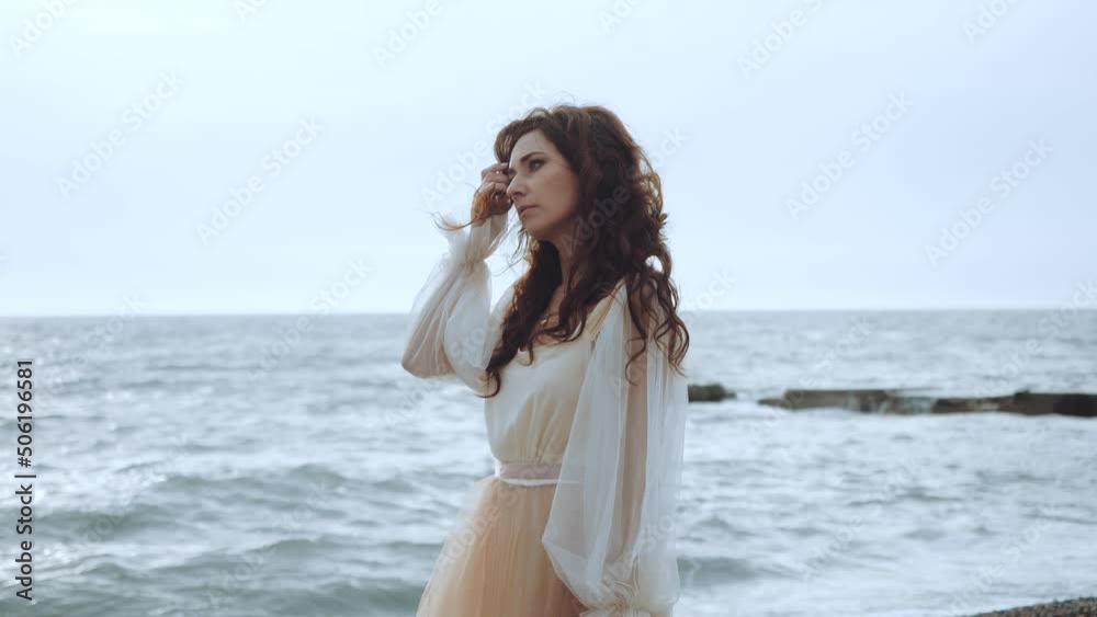 A girl on the background of sea waves walks along the beach A girl on the background of sea waves walks along the beach