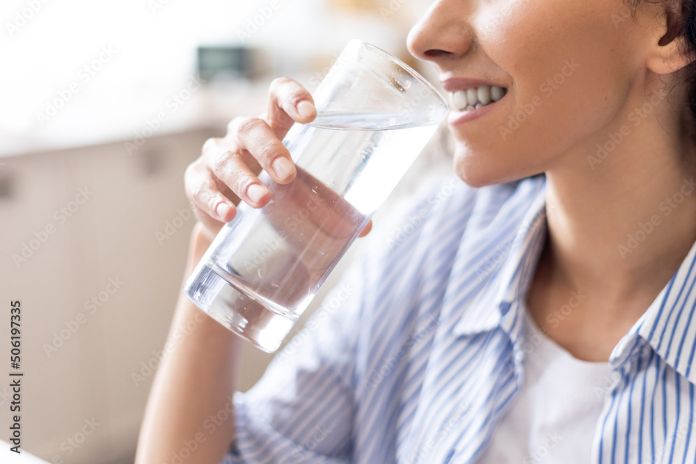 Body hydration concept. Young lady enjoying mineral water, thirsty woman drinking refreshing liquid from glass Body hydration concept. Young lady enjoying mineral water, thirsty woman drinking refreshing liquid from glass