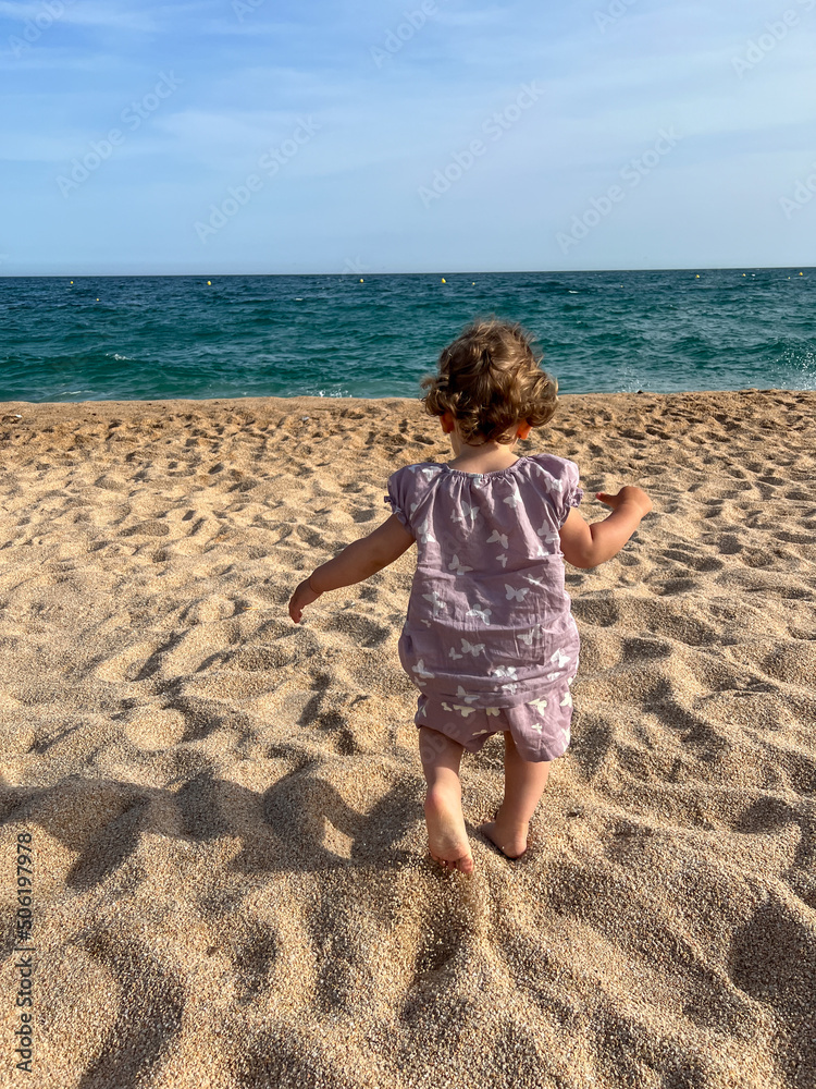 little girl walking on the beach, vertical photo little girl walking on the beach, vertical photo