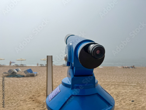 telescope on the beach during a natural phenomenon - sea fog, selective focus