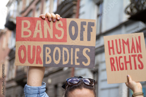 Protesters holding signs Bans Off Our Bodies and Human rights. People with placards supporting abortion rights at protest rally demonstration. © Longfin Media