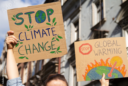 Protesters holding signs Stop Climate Change and Stop Global warming. People with placards at protest rally demonstration strike. © Longfin Media