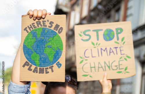 Protesters holding signs with slogans There's no planet B and Stop Climate Change. People with placards at protest rally demonstration, strike against global warming.