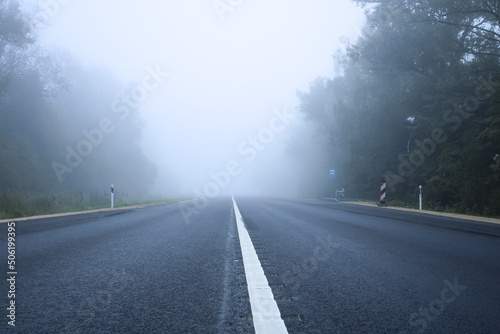 Empty road with white line. Fog on the road. Danderous foggy weather. 