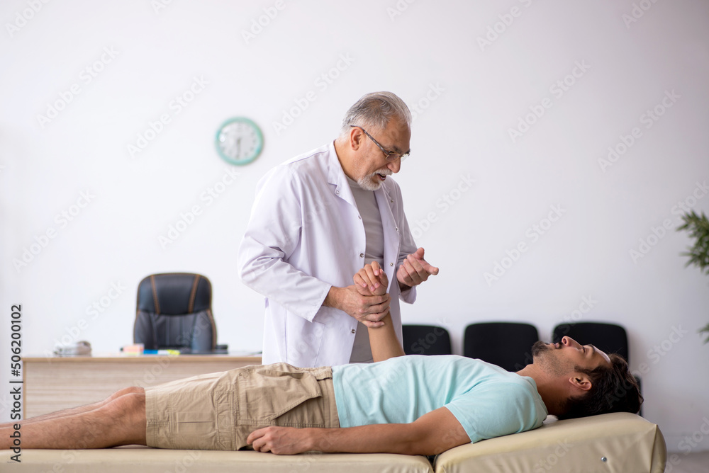 Young male patient visiting old male doctor Young male patient visiting old male doctor