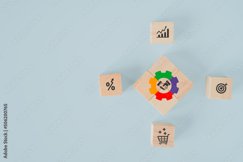 arranged wooden cube blocks with multi color of gear icon with shake hand icon inside on blue background, for key to success, cooperation, marketing and team work concept arranged wooden cube blocks with multi color of gear icon with shake hand icon inside on blue background, for key to success, cooperation, marketing and team work concept