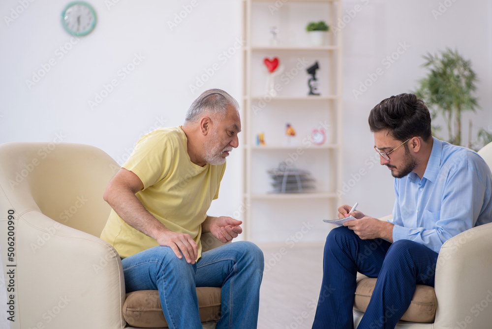 Obraz premium Old man visiting young male psychotherapist