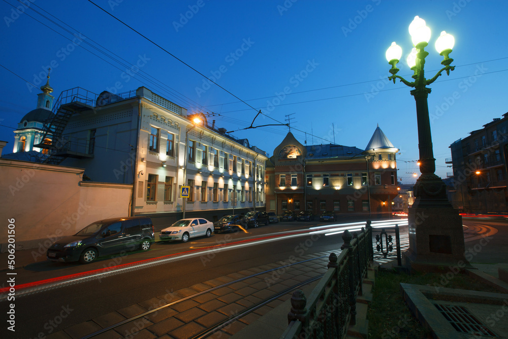 Fototapeta premium Moscow, Russia - July, 27 2014: Historical buildings in Moscow center at night. Mansion on Yauza boulevard. Tram rails and light traces on foreground.
