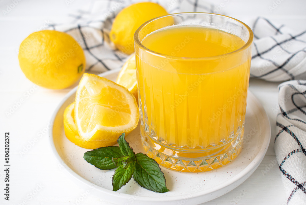 fresh lemon juice with mint in a glass on the table fresh lemon juice with mint in a glass on the table