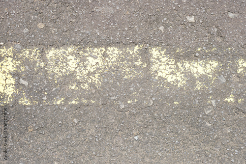 old road surface has yellow lines peeling off.