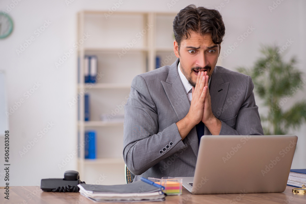 Young male employee sitting in the office