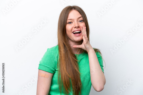 Young caucasian woman wearing a band aids isolated on white background shouting with mouth wide open