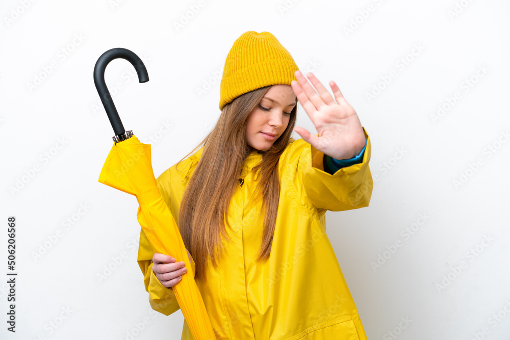 Young caucasian woman with rainproof coat and umbrella isolated on white background making stop gesture and disappointed Young caucasian woman with rainproof coat and umbrella isolated on white background making stop gesture and disappointed