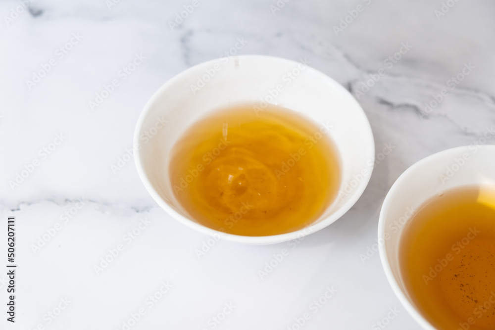 Tea drops fall into a cup. Tea ceremony concept Tea drops fall into a cup. Tea ceremony concept