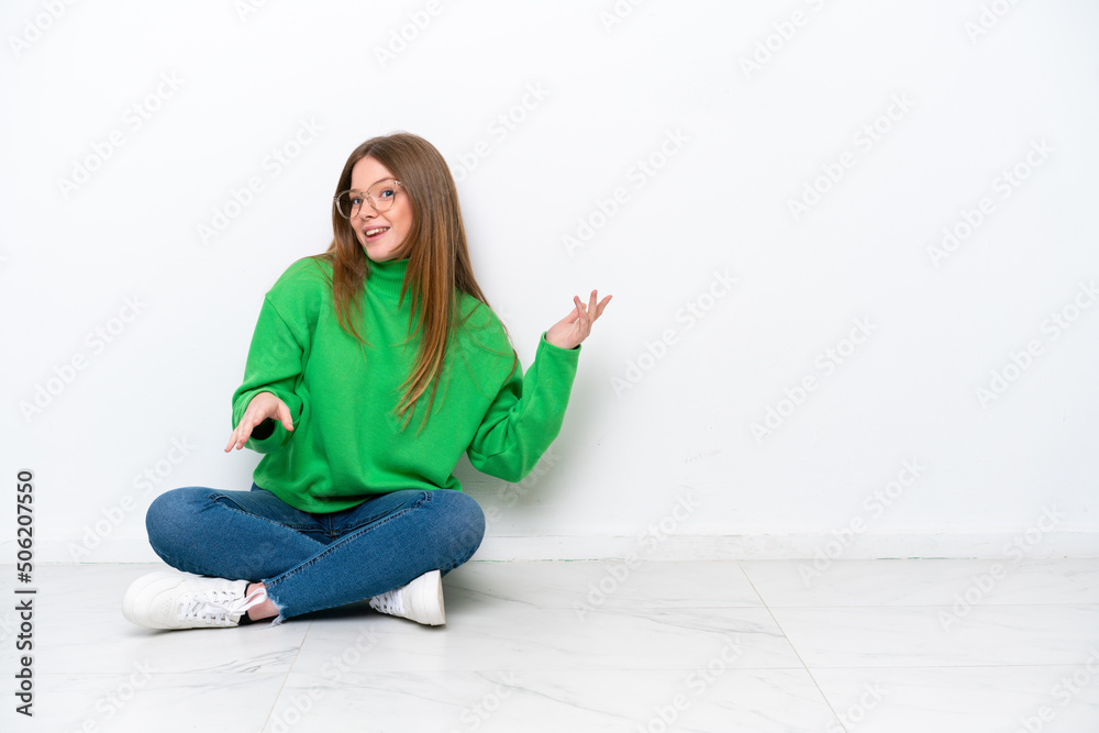 Young caucasian woman sitting on the floor isolated on white background making guitar gesture Young caucasian woman sitting on the floor isolated on white background making guitar gesture