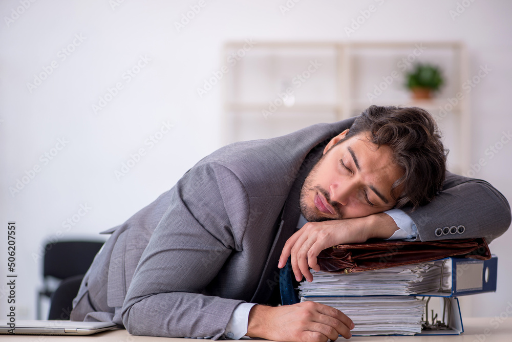 Obraz premium Young male employee in oversleeping concept