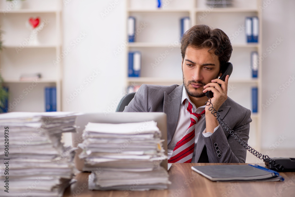 Young male employee unhappy with excessive work in the office